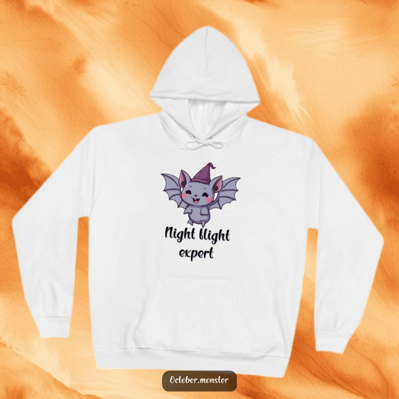 Funny spooky bat wearing a tiny pointed hat, joyfully floating, on a warm hoodie, perfect for chilly Halloween nights.